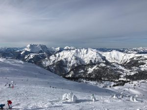 Skipiste im Vodergrund. Im Hintergrund das Alpenpanorama.